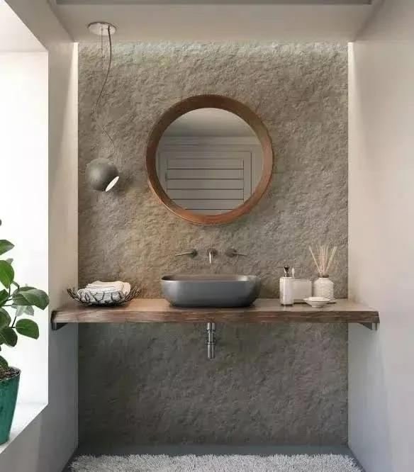 Lavabo com parede em revestimento texturizado e bancada de madeira