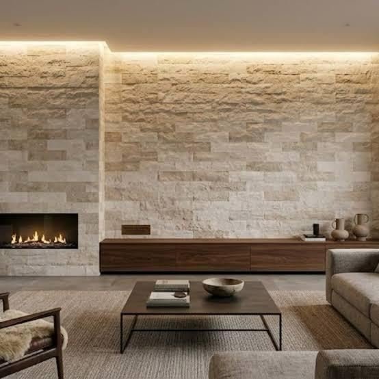 Sala com parede de revestimento efeito pedra e iluminação indireta